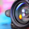 Close up of camera lens in front of colourful background