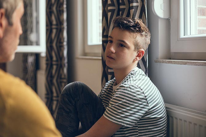 Young person talking to an adult in a room